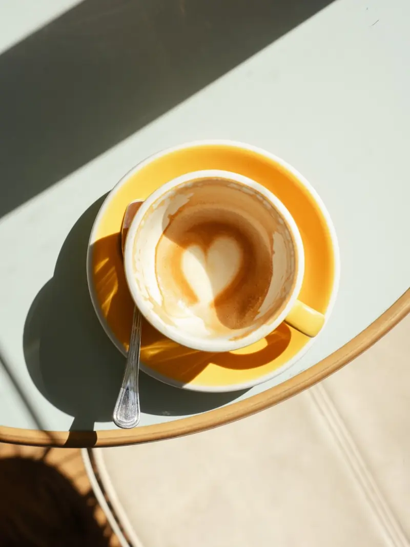 Une tasse de café au soleil sur une table ronde