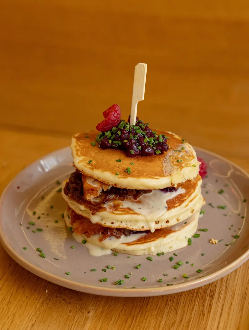 Pile de chicken pancakes, poulet crispy et oignons caramélisés